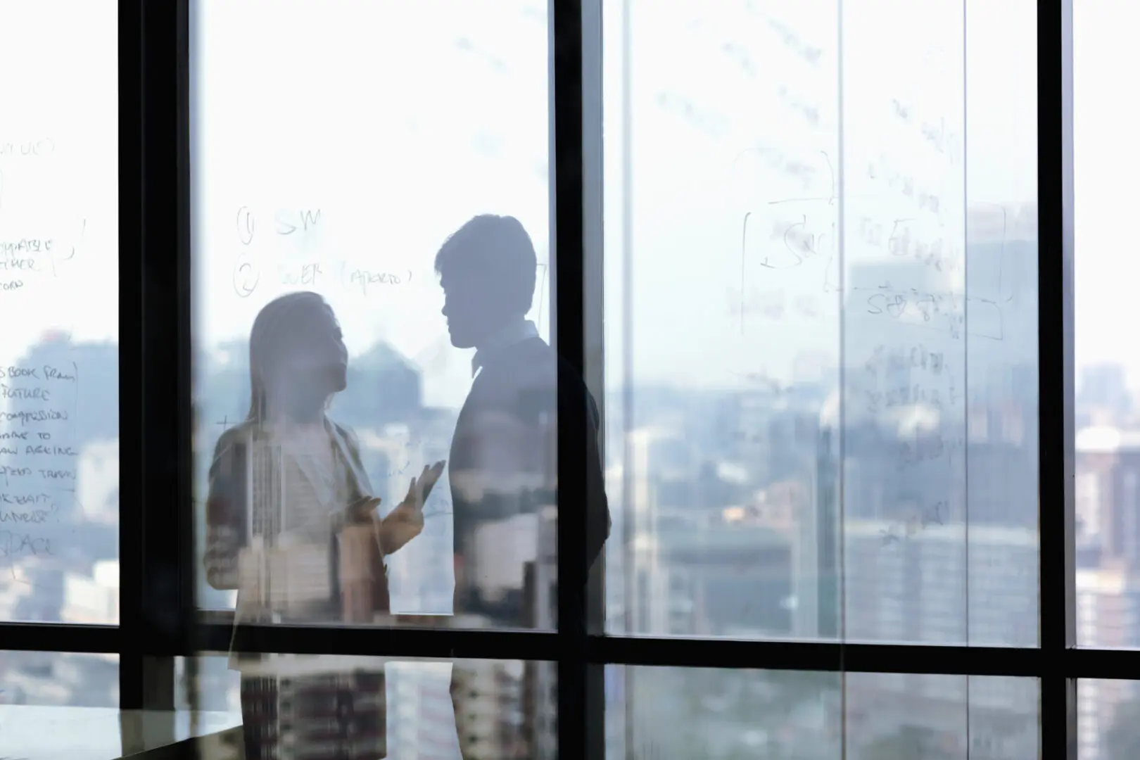 Silhouetted discussion in modern office setting.